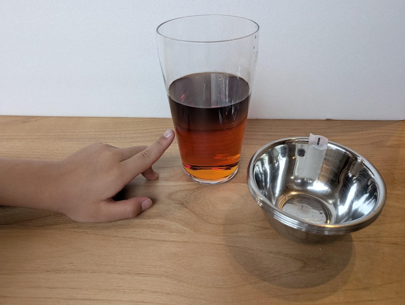 子どもが指をさしているグラス。上が黒っぽく、下がオレンジ色に分かれている