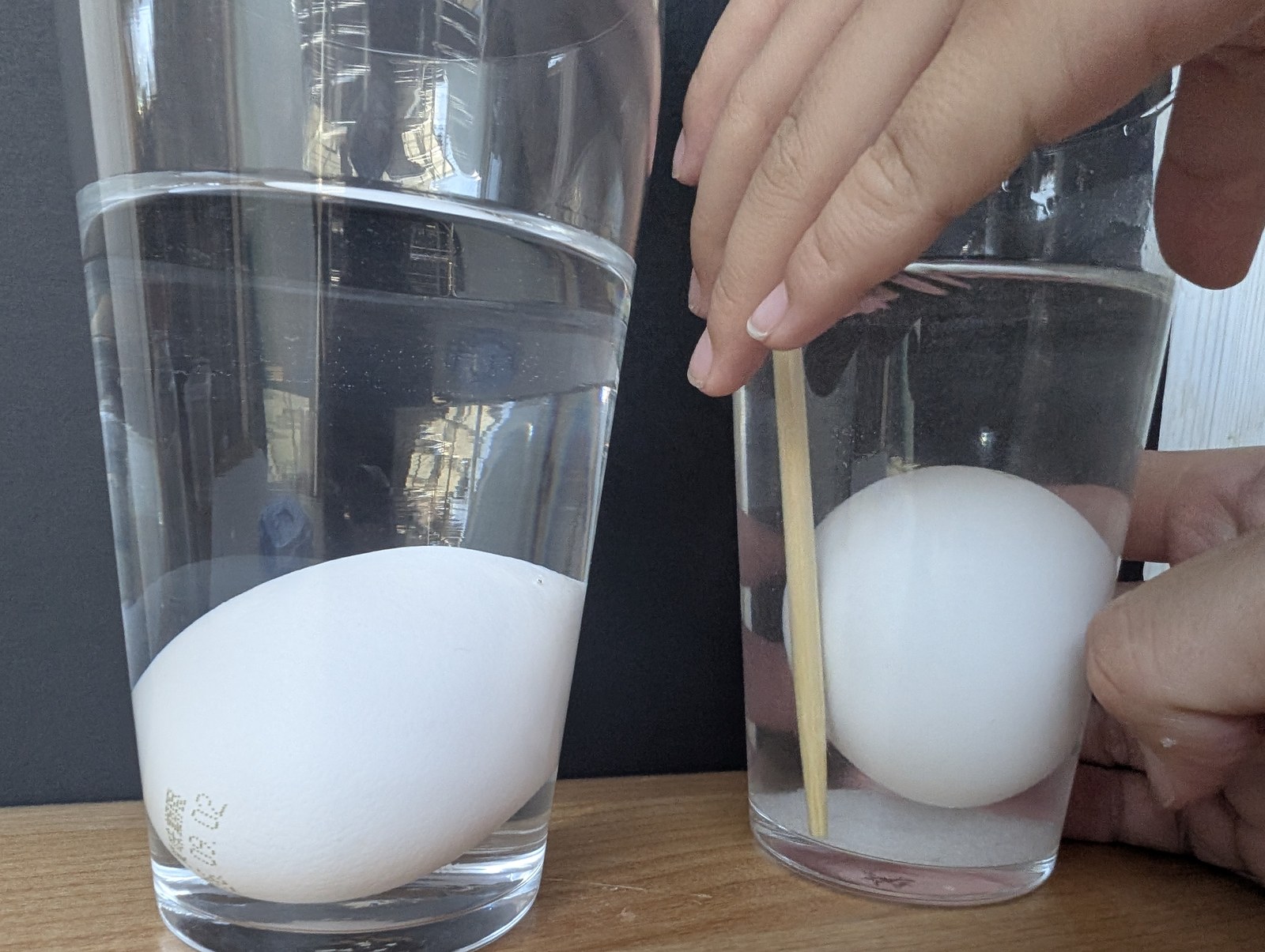 卵が入ったままのコップを菜箸でかき混ぜているところ。底には塩がたまっている