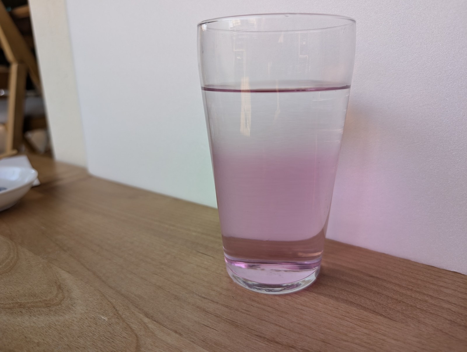 コップの中の水が、下はピンク、上は透明の2層に分かれた写真